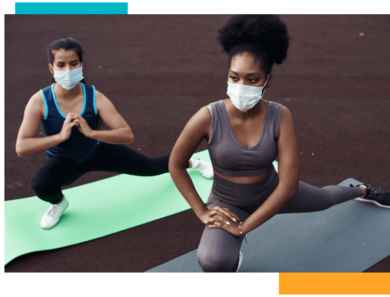 two women doing yoga with face masks